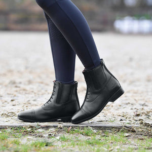 Busse Reitstiefeletten Apia Lace aus Rindsleder mit Brogue-Design und YKK-Reißverschluss beim Tragen im Reitstall. Ideal für Reitsport-Einsätze.