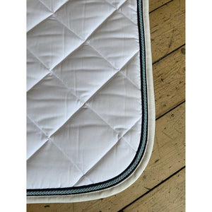 Detailansicht der Quola Springschabracke mit grün-schwarzer Kordel und robuster Baumwollstruktur. Ideal als Sattelunterlage für Pferde.