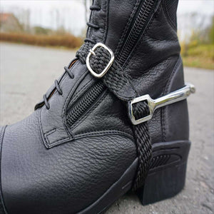 Kavalkade Sporenriemen Perlon – geflochten und verstellbar, sicher befestigt an einem schwarzen Reitstiefel mit Sporen.
