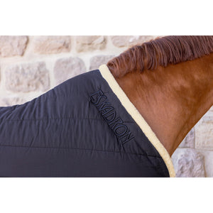 Nahaufnahme des Eskadron-Logos auf der Stalldecke Cotton Fauxfur mit Fauxfur-Kragen, betont hochwertige Verarbeitung.