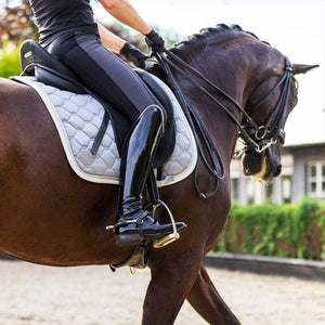 Reiterin auf Pferd mit schwarzer Equestrian Schabracke aus der Glitter-Rand Kollektion, ideal für Dressur und täglichen Reitkomfort.