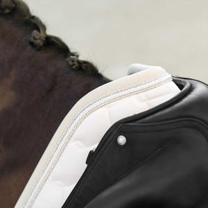 Detailansicht der weißen Equestrian Schabracke mit Glitter-Rand unter schwarzem Sattel, perfekte Passform und Komfort für Pferd und Reiter.