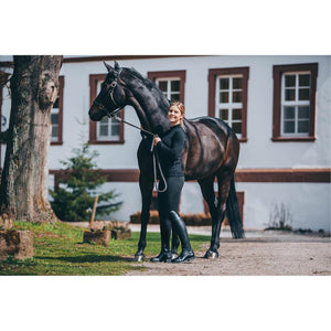 Reiterin mit Suedwind Nova Tall Vegan Reitstiefeln neben schwarzem Pferd, ideal für stilbewusste Reiter im Alltagseinsatz.
