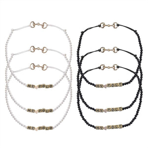 HV Polo Armband Kristie mit Perlen in Weiß und Schwarz, verziert mit Metallgebissbesatz und goldenen Buchstabenperlen – stilvoller Schmuck kaufen.