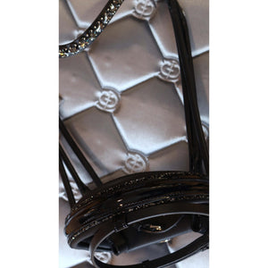 Detailansicht der rundgenähten Trense München von Otto Schumacher mit glänzendem Lackleder und Jet Platin Zierkeder für Pferde.