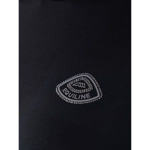 Nahaufnahme des Equiline Logos mit Glitzersteinen auf dem schwarzen Funktionsshirt Geco Winter 2025 / 2026 für Damen.