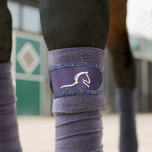 Lila Equestrian Fleecebandagen mit glitzerndem Satin-Klettverschluss und Pferdekopf-Logo, perfekt für stilvollen Beinschutz beim Turnier.