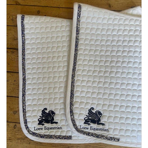 Detailansicht der Loew Turnierschabracke Swarovski mit Loew-Logo und Swarovski-Besatz, ideal als elegante Schabracke für Turniere.