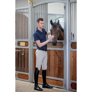 Reiter trägt Catago Herrenreithose Vollbesatz Nero im Stall mit Pferd, perfekte Reithose fürs ganze Jahr. Stilvolle Herrenbekleidung von Catago.