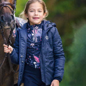 Mädchen trägt die Imperial Kinder Tech Jacke Winter beim Reiten, mit reflektierendem Logo und wetterfester Ausstattung für kalte Tage.
