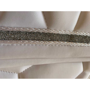 Detailansicht der Catago Turnierschabracke Naomi in Weiß mit glitzernder Silberbiese und eleganter weißer Kordel für Dressurturniere.