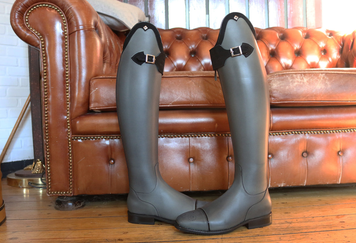 DeNiro-Kundenstiefel bei Reitsport Loew: Graue Stiefel mit dunklen Abschlüssen und Schnallen.