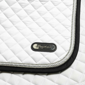 Detailansicht der weißen Kingsland Schabracke KLCameo mit silberner Kordel und Logo-Plakette. Hochwertige Verarbeitung für sportliche Eleganz im Reitsport.