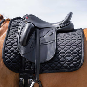 EUROSTAR Schabracke Cato Sommerkollektion in Schwarz unter einem Dressursattel auf einem Pferd. Atmungsaktive Sattelunterlage mit 3D Mesh für Komfort im Sommer.